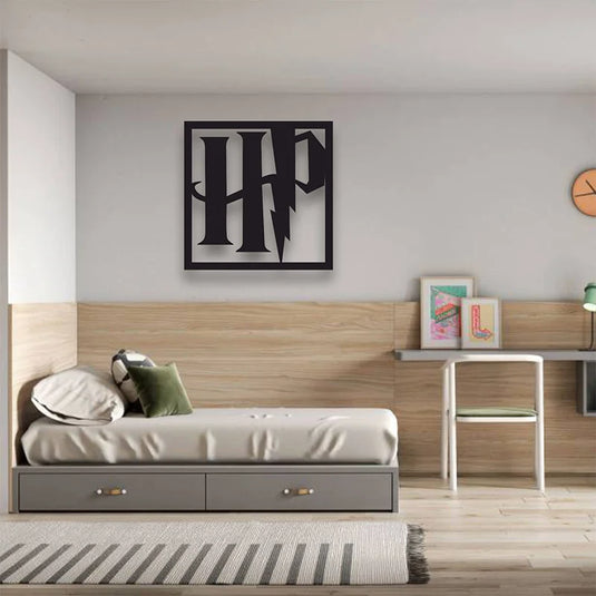 Cuadro decorativo de aluminio recortado con el logo de Harry Potter colgado en la pared de una habitación juvenil moderna.