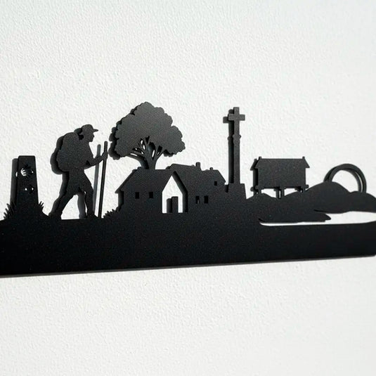 Detalle ampliado de la silueta del Camino de Santiago en madera, con mojón, peregrino, casas rurales, crucero y hórreo gallego fabricados con precisión artesanal