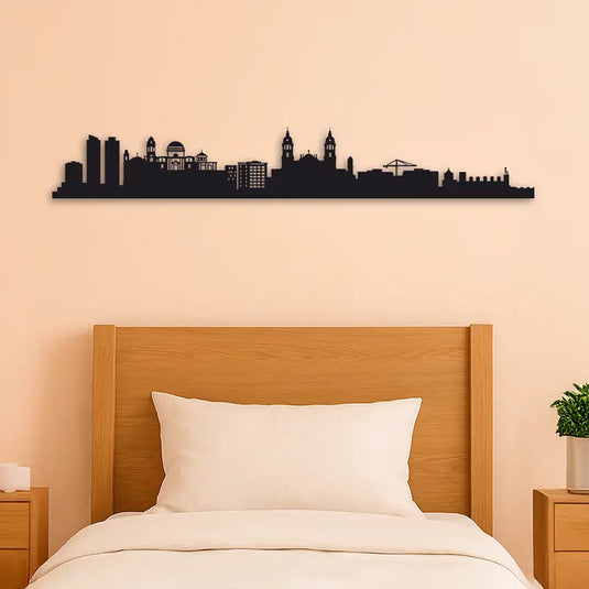 Skyline de Cádiz en madera pintada a mano colocado sobre cabecero de cama. Decoración mural elegante para dormitorios, con silueta artística de la ciudad de Cádiz en DM negro de 7 mm. Regalo perfecto para amantes de Andalucía y la decoración original.