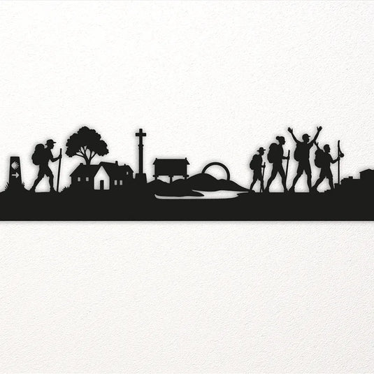 Detalle de la silueta del Camino de Santiago en madera, con peregrinos, casas rurales, crucero y hórreo gallego tallados con precisión artesanal