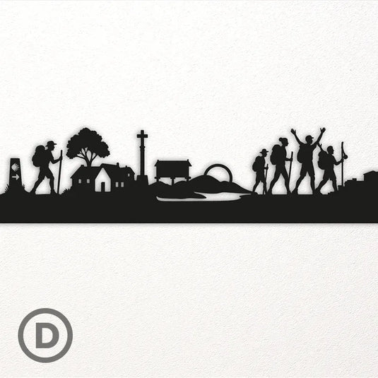 Detalle de la silueta del Camino de Santiago en madera, con peregrinos, casas rurales, crucero y hórreo gallego tallados con precisión artesanal