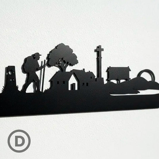 Detalle ampliado de la silueta del Camino de Santiago en madera, con mojón, peregrino, casas rurales, crucero y hórreo gallego fabricados con precisión artesanal