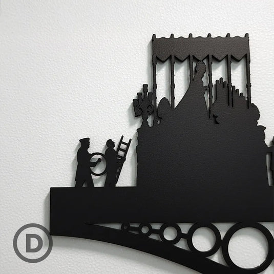 Detalle ampliado de silueta de madera representando la Virgen de la Esperanza sobre el Puente de Triana en Sevilla, decorando una pared blanca.