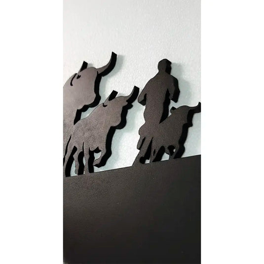 Detalle de textura de madera y acabado en pintura negro mate del skyline que representa un corredor rodeado de toros bravos durante un encierro de San Fermín.