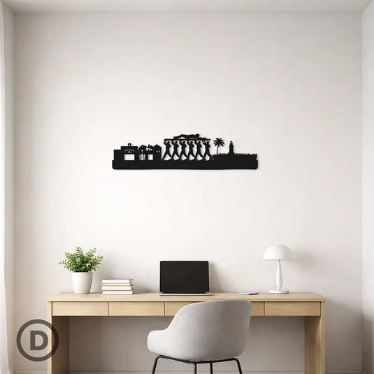 Mockup de decoración con skyline en silueta negra de la procesión del Cristo de la Buena Muerte (Legionarios) de Málaga, colocado en una pared sobre un escritorio.